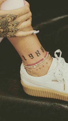 a close up of a person's foot with a tattoo on her left ankle