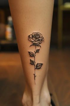 a woman's foot with a rose tattoo on the side of her leg,