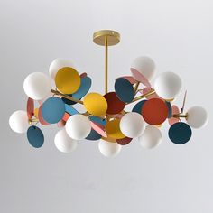 a colorful chandelier hanging from a ceiling in a room with white walls and flooring