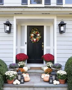 front porch decorated for fall with pumpkins and flowers