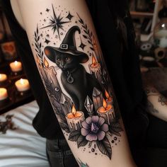 a black cat with a witches hat on it's arm is surrounded by candles