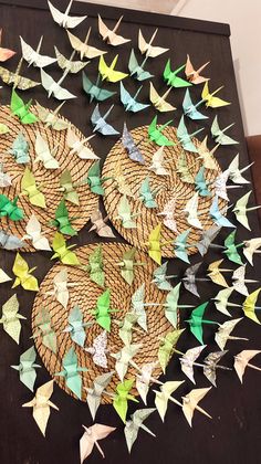 several paper birds are arranged in the shape of baskets on a black surface with strings attached to them