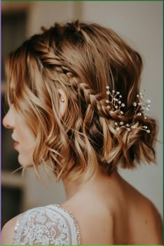 the back of a woman's head with braids and flowers in her hair