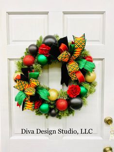 a christmas wreath is hanging on the front door with balls and decorations in green, red, yellow and black