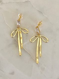 For all the bow lovers🎀 Material: 16k gold plated on brass Gold Wedding Jewelry With Butterfly Knot Detail, Chic Yellow Gold Jewelry With Bow Detail, Chic Yellow Gold Jewelry With Bow, Metal Bow Earrings For Gifts, Elegant Metal Bow Earrings, Chic Metal Jewelry With Bow Detail, Gold Dangle Jewelry With Bow, Gold Ribbon Earrings For Party, Chic Gold Earrings With Decorative Bow