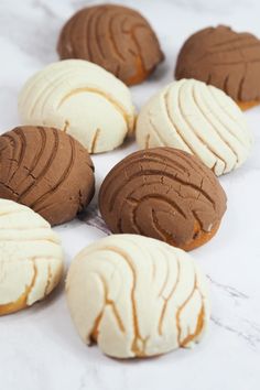 there are many different types of cookies on the counter top, including one with white frosting