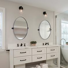 a bathroom with two sinks, mirrors and a bathtub in the middle of it