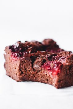 two pieces of brownie with raspberry toppings on top and one piece cut in half