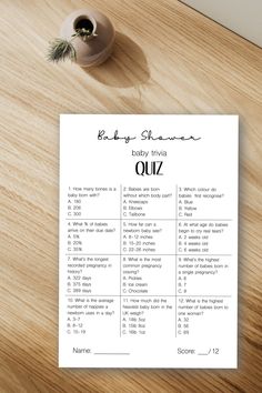 the baby shower quiz is sitting on top of a wooden table