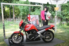 a woman standing next to a red motorcycle