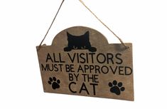 a wooden sign with a cat saying all visitors must be approved by the cat on it