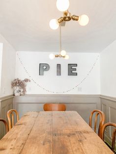 a wooden table sitting in front of a white wall with the word pie on it