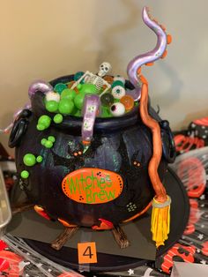 there is a witches pot on top of the table with decorations and candy in it