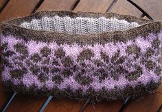 a knitted basket sitting on top of a wooden table