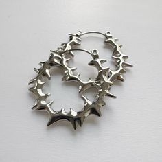 Elevate your style with these bold, spiky stainless steel hoop earrings. 100% high polished stainless steel, 1" diameter. The modern design features smooth spiky that add an edgy statement to any look. Made from durable stainless steel, these earrings have some weight to it, although comfortable for all-day wear, it might not be weight sensitive ears friendly. Add a touch of contemporary attitude to your ensemble with these standout hoops. We ship in 1-3 days, all purchases come with complimentary jewelry pouch and box. Edgy Metal Hoop Earrings, Nickel-free Edgy Hoop Earrings, Edgy Small Hoop Nickel-free Earrings, Edgy Hoop Earrings For Pierced Ears, Punk Small Hoop Metal Earrings, Punk Style Small Hoop Metal Earrings, Edgy Small Hoop Metal Jewelry, Edgy Stainless Steel Hoop Earrings, Punk Stainless Steel Hoop Jewelry