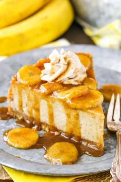 a piece of cheesecake on a plate with bananas in the background and caramel sauce drizzled over it