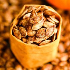 a wooden bowl filled with roasted pumpkin seeds