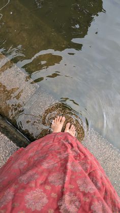 a person standing in the water with their feet up