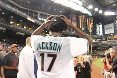 a baseball player saluting the crowd at a game in an empty stadium with fans