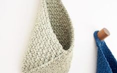 a crocheted hanging basket next to a blue and white towel on a hook