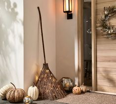 a broom sitting on the ground next to some pumpkins