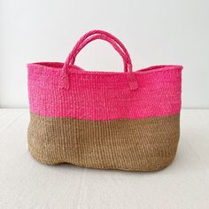 a pink and brown bag sitting on top of a white table