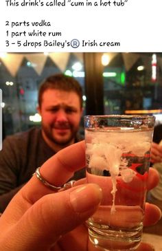 a man holding up a glass filled with ice and water in front of his face