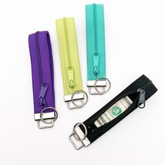 three different colored zippers with money sticking out of them