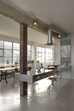 an industrial style kitchen and dining room with large windows