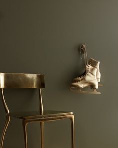 a pair of ice skates hanging on the wall next to a chair