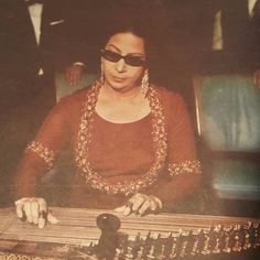 an old photo of a woman playing a musical instrument