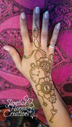 a woman's hand with henna tattoos on it