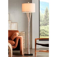 a living room scene with focus on the floor lamp and tree - like object in the foreground