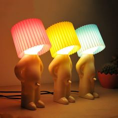 three different colored lamps sitting on top of a table