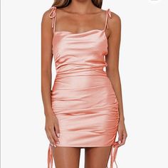 Never Worn!! Satin Cowl Neck Peach/Pink Mini Dress Sides Scrunch Up And Length To Be Tied Straps Tie So Can Adjust To Any Size Zippers Down The Side Pink Mini Dress With Spaghetti Straps And Tie Back, Pink Flirty Tie-back Mini Dress, Flirty Peach Sleeveless Mini Dress, Peach Mini Dress For Summer Night Out, Peach Mini Dress For Night Out In Summer, Chic Peach Mini Dress For Party, Peach Mini Dress For Summer Party, Peach Mini Dress For Party, Casual Peach Mini Dress For Party