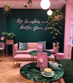 a pink and green living room filled with furniture next to a wall that says, not photos are better than yours