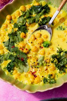 a bowl filled with soup and garnished with green leafy vegetables on top