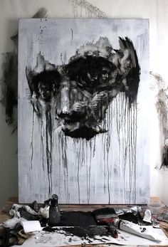 an art work with black and white paint dripping down the wall next to it is a large piece of artwork