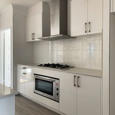 a kitchen with white cabinets and stainless steel appliances