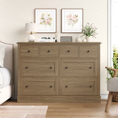 a bedroom scene with focus on the chest of drawers and two framed pictures above it