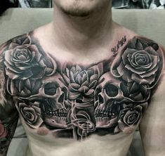 a man's chest with skulls and roses on it