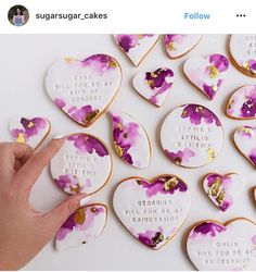 a hand is pointing at some decorated cookies