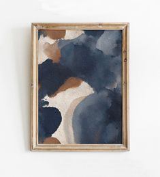 an abstract painting hangs on the wall next to a white wall with a wooden frame