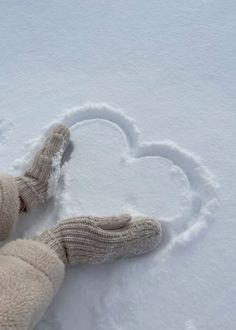 a teddy bear laying in the snow with a heart drawn on it's side