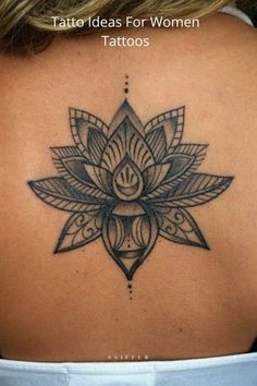 the back of a woman's shoulder with tattoos on it and an image of a lotus