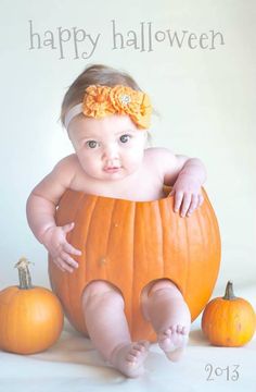 a baby is sitting in a pumpkin with two small pumpkins around her and the words happy halloween written on it