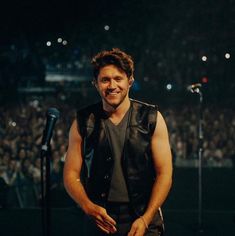 a man standing in front of a microphone at a concert