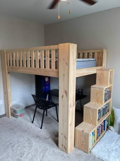 a loft bed with stairs and bookshelf in the corner next to a desk