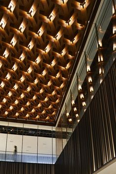 the ceiling is made up of wooden panels and lights that are suspended from them,