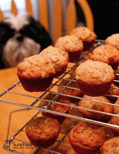 muffins cooling on a rack with a cat in the background